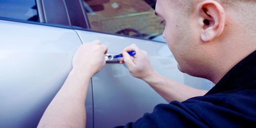 Experienced automotive locksmith in OKC unlocking a car