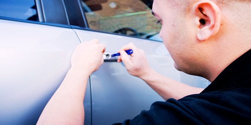 Experienced automotive locksmith in OKC unlocking a car